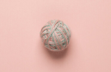 Ball of thread on pink pastel background. Top view