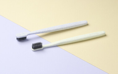 Two plastic toothbrushes on a pastel background. Oral hygiene