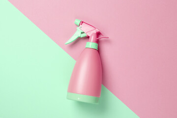 Green-pink plastic spray bottle on a pastel background. Top view. Minimalism