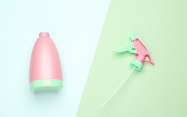 Green-pink plastic spray bottle on a pastel background. Top view. Minimalism