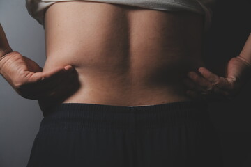 Asian fat man in front of a mirror looks at his body. Excess belly fat, Unhealthy lifestyle, Diet concept.