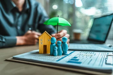 A wooden doll and wood house under an umbrella holding by agent represent insurance . house Family , protection, life. © Charnchai saeheng