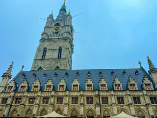  Stunning view of belfry tower and cathedral in historic Ghent under blue skies