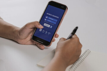 woman hand holding smart phone to access her mobile banking and holding her card