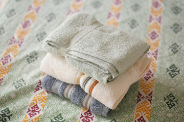 Soft towels arranged on a bed 