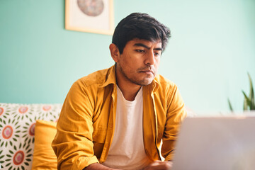 joven profesional latino trabajando desde casa con laptop – home office en Lima