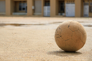雨上がりの運動場に残されたサッカーボール
