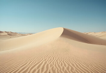 Tranquil expanse of sand dunes with rippled patterns under a serene blue sky