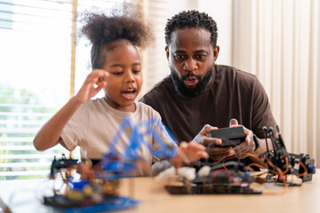 African father and daughter playing with stem robot kit, stem toys for kids fun learning and...