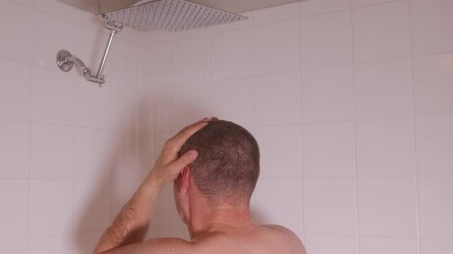 A man enjoys a rejuvenating shower experience, showcasing a truly relaxing selfcare moment for himself