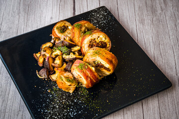 chicken roulade with sauteed mushrooms served on a black platter