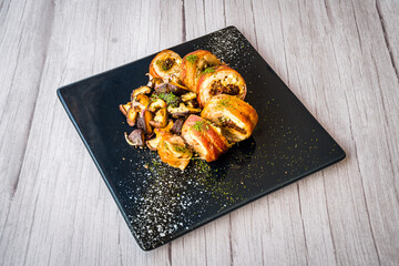 chicken roulade with sauteed mushrooms served on a black platter