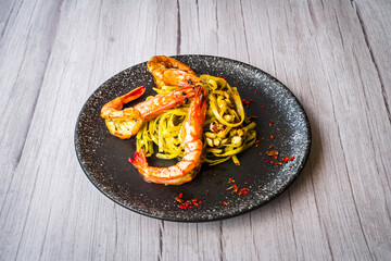 Chimichuri Pasta with Tiger Prawn served on a black plate