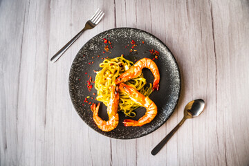 Chimichuri Pasta with Tiger Prawn served on a black plate