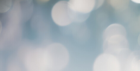 Abstract bokeh background with soft blue and white tones creating a blurry effect.