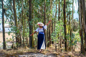 Indigenous woman walking in eucalyptus forest, otavalo, ecuador