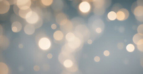 Abstract blurred background with golden bokeh lights on a soft blue surface.