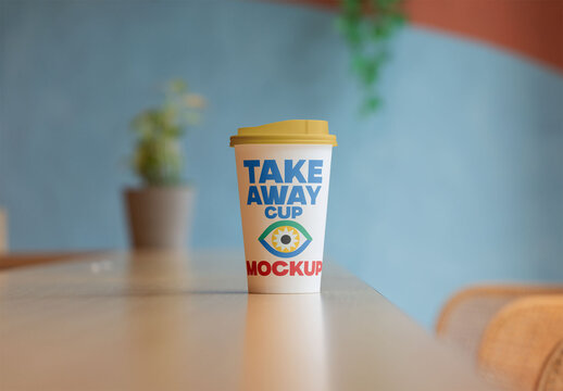 Mockup of a Takeaway Coffee Cup on a Table