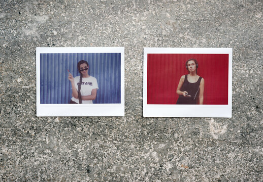 Two empty instant photo frames placed on a rough surface.