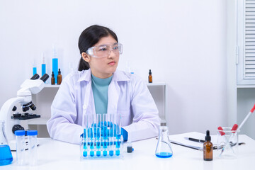 Fototapeta premium Scientist girl in lab coat observing chemical substance with care during experiment. Science, laboratory, scientist, experiment, and research represent discipline and education, healthcare.