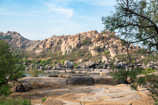 Fototapeta Tungabhadra river with boulders in Hampi, rocky terrain landscape, South India, Karnataka, travel destination