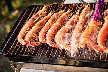 Succulent shrimp grilling, filling the air with smoky flavors on a sunny afternoon