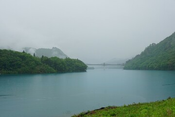 八ツ場湖の駅丸岩から見えるブルーの吾妻川と橋（雨の日）