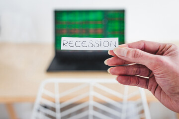 recession and stock market volatility after the pandemic, Recession text in front of computer screen with financal markets results
