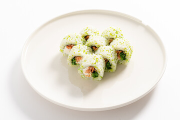 Savor the flavors of fresh sushi rolls adorned with vibrant green toppings on a white dish
