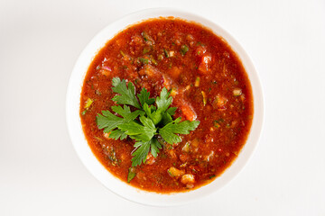 Bright salsa featuring tomatoes, peppers, and herbs garnished with fresh parsley atop a bowl