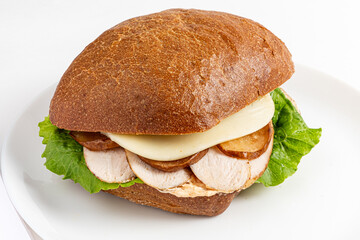 A tasty sandwich with tender roasted chicken, creamy cheese, and crisp lettuce on crusty bread