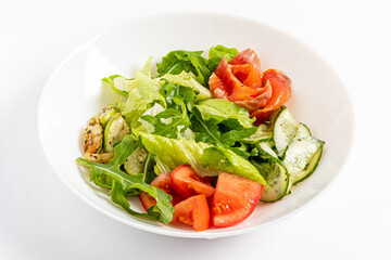 A colorful salad boasts crisp lettuce, juicy tomatoes, fresh cucumbers, and flavorful smoked salmon