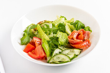 A fresh salad with vibrant greens, tomatoes, and smoked salmon