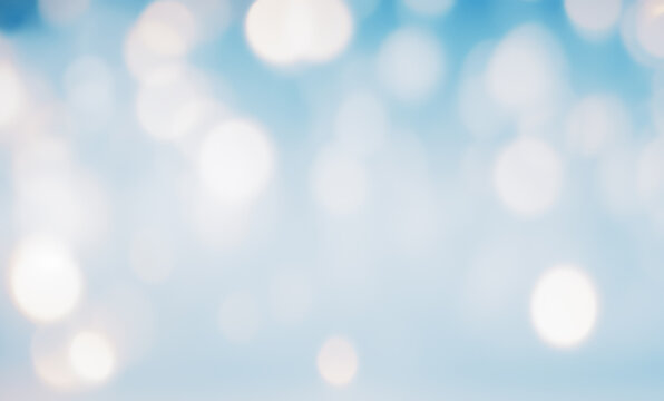 Blurred abstract background with bokeh lights in blue and white colors.
