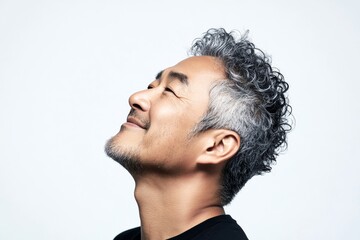 A confident and happy man exuding charm. Visual idea of style for aging men. Pure white solid background. Elegant men's fade haircut - midlife southeast asian man with curly hair.