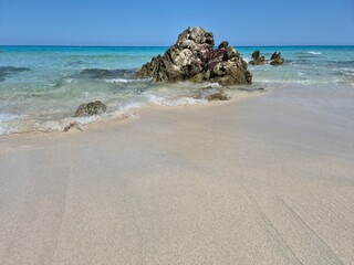 white sand, a few rocks and crystal clear water at the beach of plage de saleccia in corsica