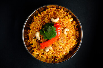 A vibrant rice dish topped with red peppers, nuts, and herbs, bursting with flavor