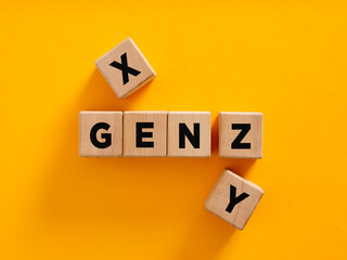 Wooden cubes composing the acronym gen z with generation x and y aside on yellow background