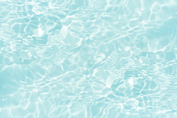 Blue water with ripples on the surface. Defocus blurred transparent blue colored clear calm water surface texture with splashes and bubbles. Water waves with shining pattern texture background.