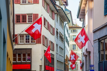 Alley in the old town of Zurich with Swiss flags displayed on buildings