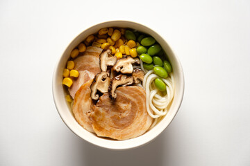 Rich flavors mingle in a bowl featuring succulent pork, vibrant corn, and fresh shiitake mushrooms