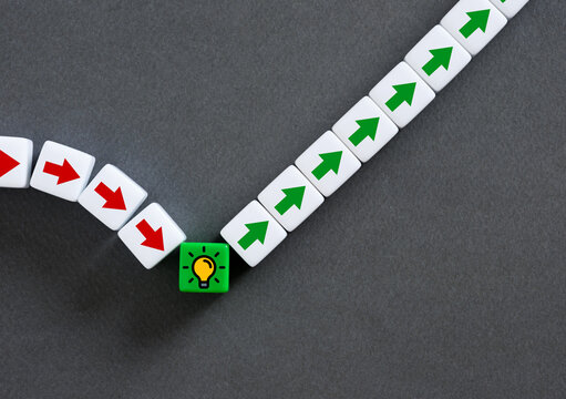 Turning point changing direction from red to green arrows with light bulb on gray background