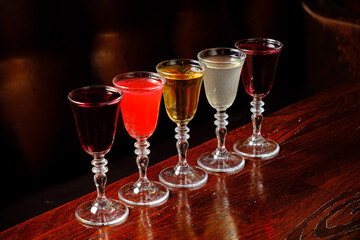Various colorful beverages sparkle in delicate glassware, inviting taste and enjoyment