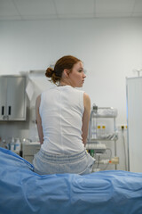Rear view of teenage girl waiting for medical examination in hospital.
