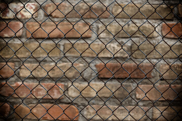Chain link fence against a brick wall