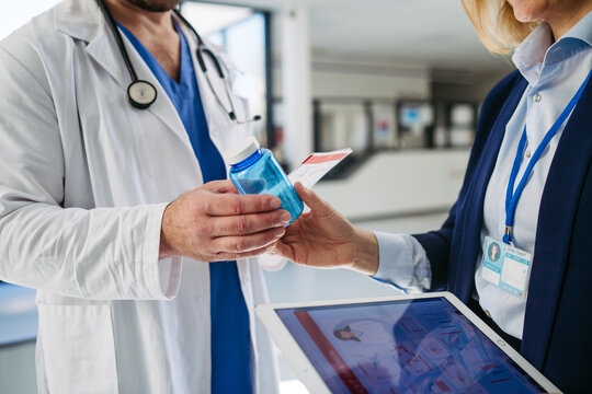 Female medical sales representative introducing pharmaceutical products to doctor.