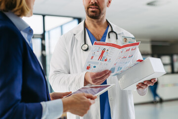 Female medical sales representative introducing pharmaceutical products to doctor.