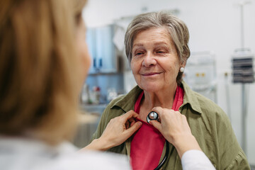 Geriatrician listening to senior patient's heartbeat.