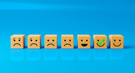 Wooden blocks displaying sad to happy faces with a green checkmark on a blue colored background