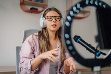 Content creator recording podcast wearing headphones and talking into microphone